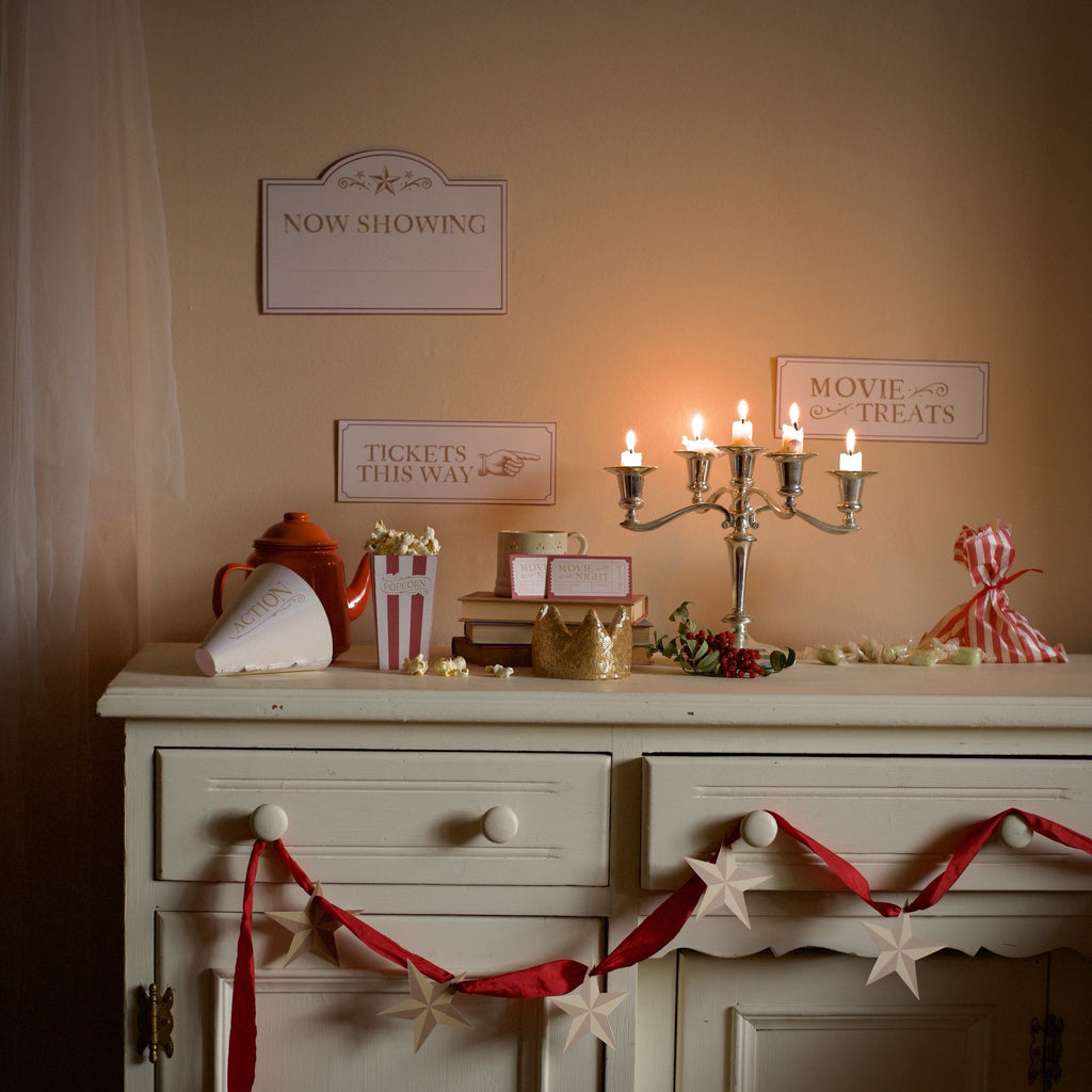 Movie Night signs, tickets and popcorn on a candlelit sideboard